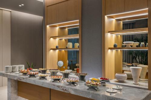 a buffet line with bowls and plates of food at Grand Hyatt Izmir IstinyePark in İzmir