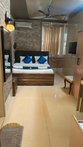 a bedroom with a large bed with blue pillows at Hotel Oliver in Mumbai