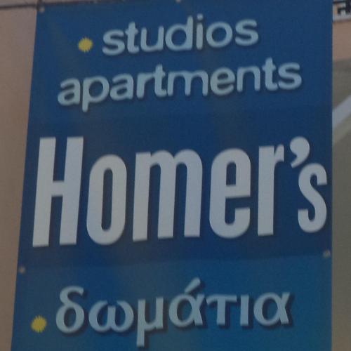 a blue sign that says students apartments homesynchronous at Homer Studio in Nydri