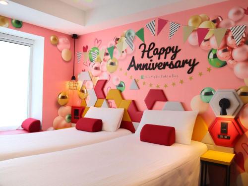 a room with two beds with a happy anniversary sign on the wall at ibis Styles Tokyo Bay in Urayasu