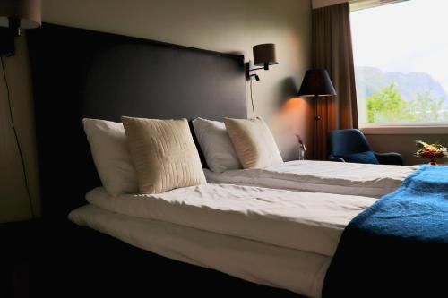 a bedroom with a large bed with white pillows at Sirdalsvatnet Hotel in Sirdal in Tonstad
