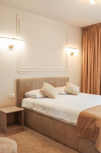 a bedroom with a bed with two pillows and a window at Ina Deluxe in Moisei