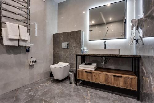 a bathroom with a toilet and a sink and a mirror at GirSki in Bukovel