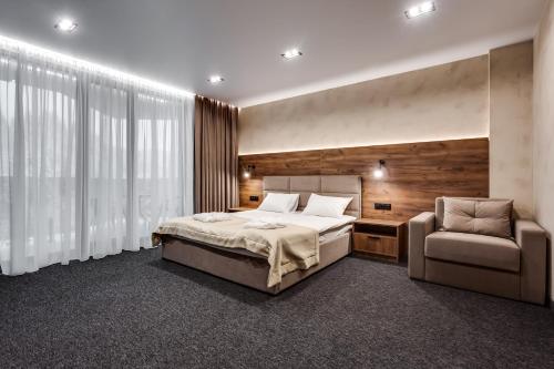 a bedroom with a bed and a chair at GirSki in Bukovel