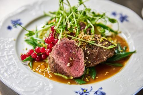 a plate of food with meat and vegetables on a table at Hotel & Restaurant Rhönhäuschen in Bischofsheim an der Rhön