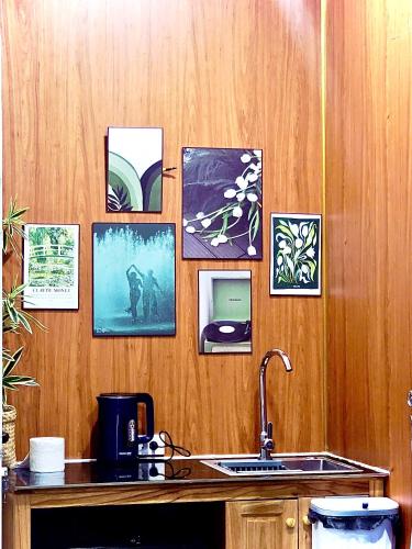 a kitchen with a sink and pictures on the wall at Sea DoSon Resort in Ðố Sơn