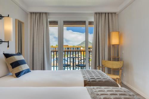 a hotel room with a bed and a balcony at Pestana Dunas All Inclusive in Porto Santo