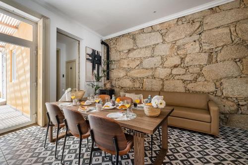a dining room with a table and a brick wall at GuestReady - Vanzeleres Collection in Porto