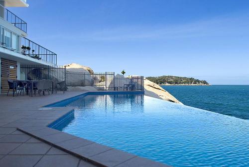 a swimming pool in front of a building next to the ocean at 1 Bright Point Apartment 5301 in Nelly Bay
