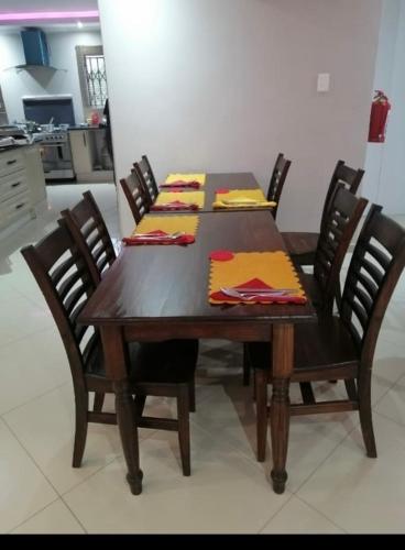 a dining room table with chairs and a wooden table with napkins at Bosago lodge and Spa in Burgersfort