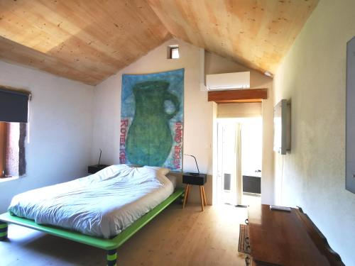 a bedroom with a bed with a vase on the wall at Gîte du Mont Gérard in La Lanterne-et-les-Armonts