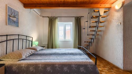 a bedroom with a bed and a spiral staircase at Villa Rossy by Villas Guide in Pavicini
