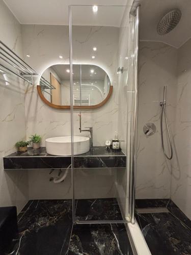 a bathroom with a glass shower and a sink at Rodolithos Beach in Stavros