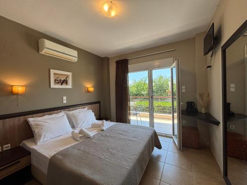 a bedroom with a bed and a sliding glass door at Rodolithos Beach in Stavros