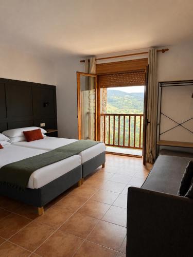 a bedroom with a large bed and a balcony at Hotel Casa Eira B&B in La Molina