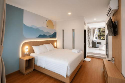 a bedroom with a large white bed and a window at Samara Villa by Sinergi in Tawangmangu
