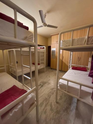 a room with two bunk beds and a ceiling fan at Pravaha Hostel in Bangalore