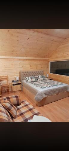 a bedroom with a large bed in a wooden cabin at Otto's House in Ambrolauri