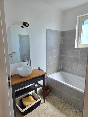 a bathroom with a sink and a bath tub and a sink at Chambre privée proche plages in Plozévet