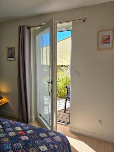 a bedroom with a door leading to a patio at Chambre privée proche plages in Plozévet