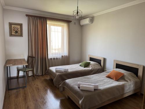 a bedroom with two beds and a table and a window at Afyan's guest house in Yerevan
