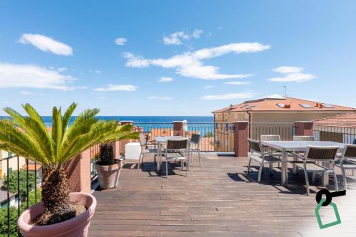 a deck with tables and chairs and a view of the ocean at HOTIDAY Room Collection - Alassio Centro in Alassio