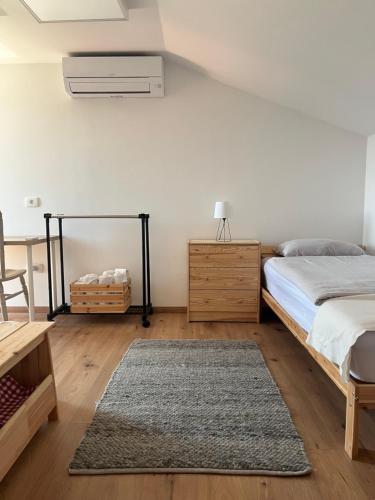 a bedroom with a bed and a table and a rug at Hramišče, Botega in Šmarje