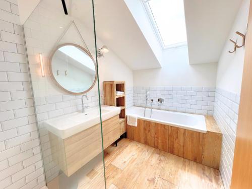 a bathroom with a sink and a tub and a mirror at VOM REITER, Ferienwohnung am Bauernhof mit Bergblick und privater Infrarotkabine, Inkl Sommercard und Spielplatz in Schladming