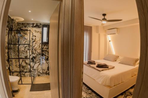 a small bedroom with a bed and a mirror at Sweet Suites in Nea Peramos
