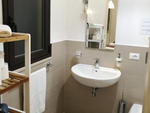 Un baño con un lavabo blanco y un espejo. en Primo Piano Riccio Locazione Turistica, en Trapani