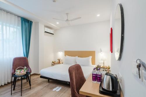 a hotel room with a bed and a table and chairs at RCC Hotels Elite Begumpet in Hyderabad