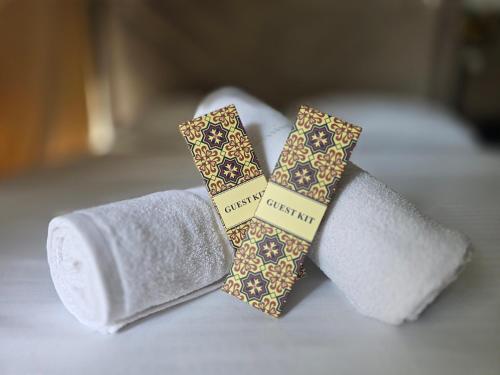two rolls of toilet paper and two ties on a bed at Sundown Lodge in San Fernando