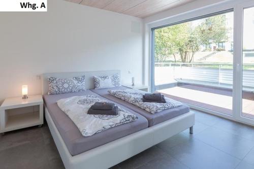 a large bed in a room with a large window at Ferienwohnung Philip in Meersburg