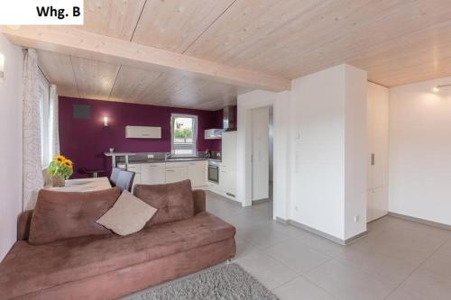 a living room with a brown couch and a kitchen at Ferienwohnung Philip in Meersburg