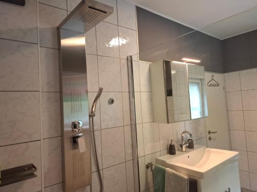 a bathroom with a shower and a sink and a mirror at Baker's Pond Apartment Two in Velden am Wörthersee