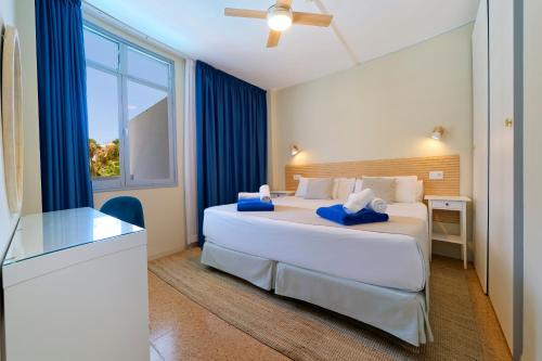 a bedroom with a large white bed and a window at Fayna Apartments in Playa del Ingles