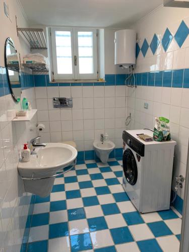 a bathroom with a sink and a washing machine at Casa Mao in Noto