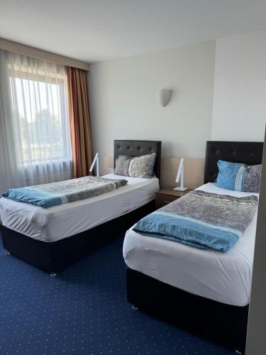 a hotel room with two beds and a window at Hotel Regina Suites in Sankt Augustin
