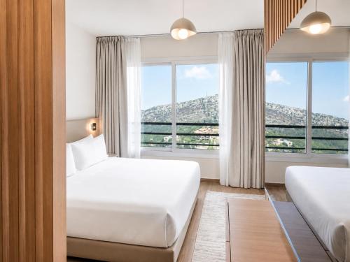 ein Hotelzimmer mit zwei Betten und einem Fenster in der Unterkunft Ridge Hotel Ehden in Ehden