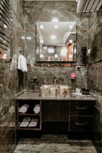 a bathroom with a sink and a large mirror at Otel Grand Lark İstanbul in Istanbul