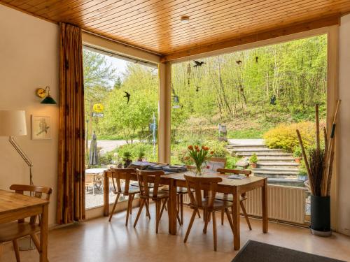 a dining room with a table and chairs and a large window at Camping La Lienne in Stoumont