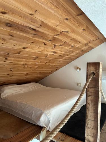 a bed in a room with a wooden ceiling at Villa Vuk in Budva