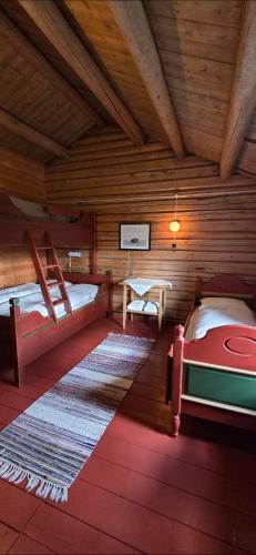 a log cabin with two beds and a table at Skotten Seter - Bed & Husky in Mork