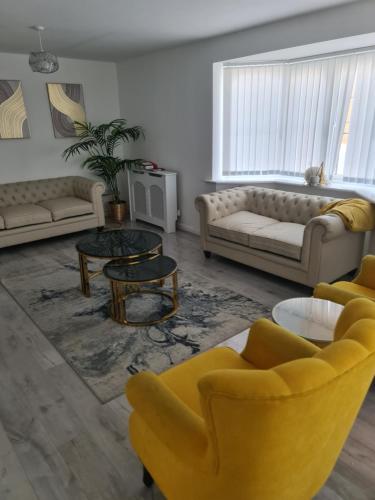 a living room with a yellow couch and tables at FV Dwelling in Nottingham