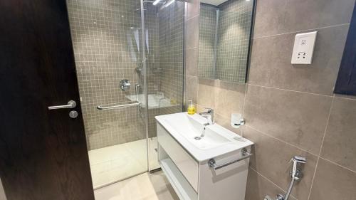 a bathroom with a sink and a shower at Navy Studio By Bait Zain in As Sīfah