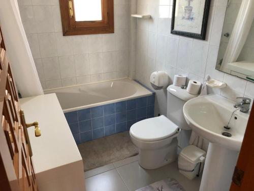 a bathroom with a toilet and a tub and a sink at Veracoast 133 in Los Amarguillos