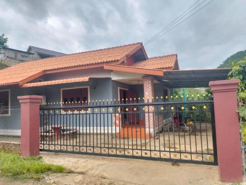 a small house with a gate in front of it at Ban Thong hostel in Luang Prabang