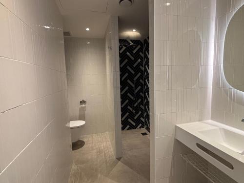 ein weißes Badezimmer mit Toilette und Waschbecken in der Unterkunft Hotel het Dok in IJmuiden