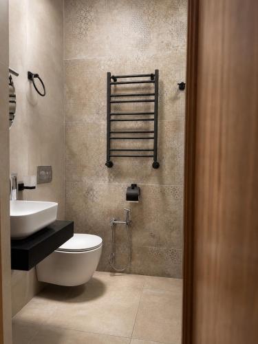 a bathroom with a toilet and a sink at Green villa panorama in Batumi