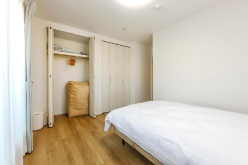 a bedroom with a white bed and a closet at Asobi Stay大日 山吹 in Nagoya